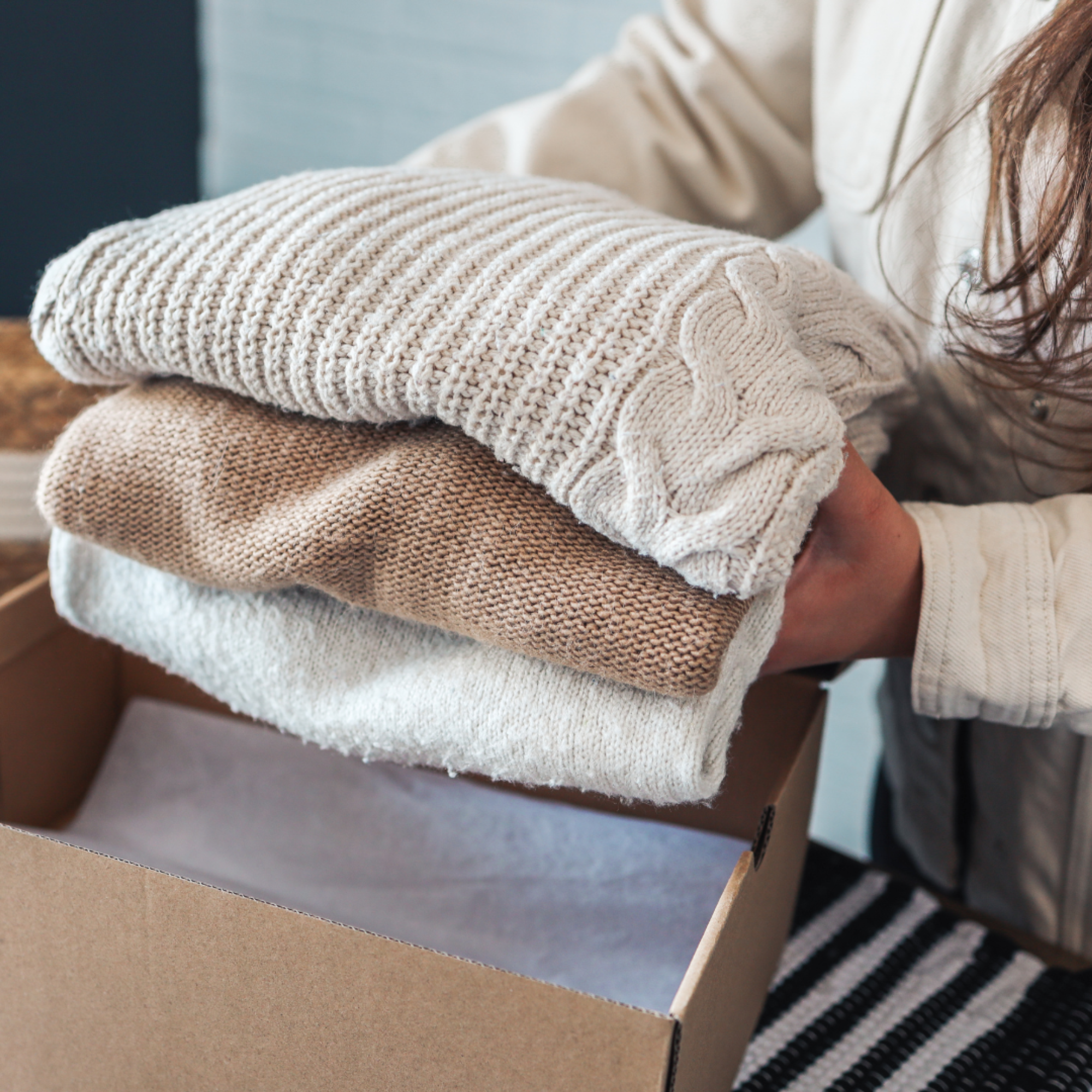 Image of a girl putting sweaters into a box