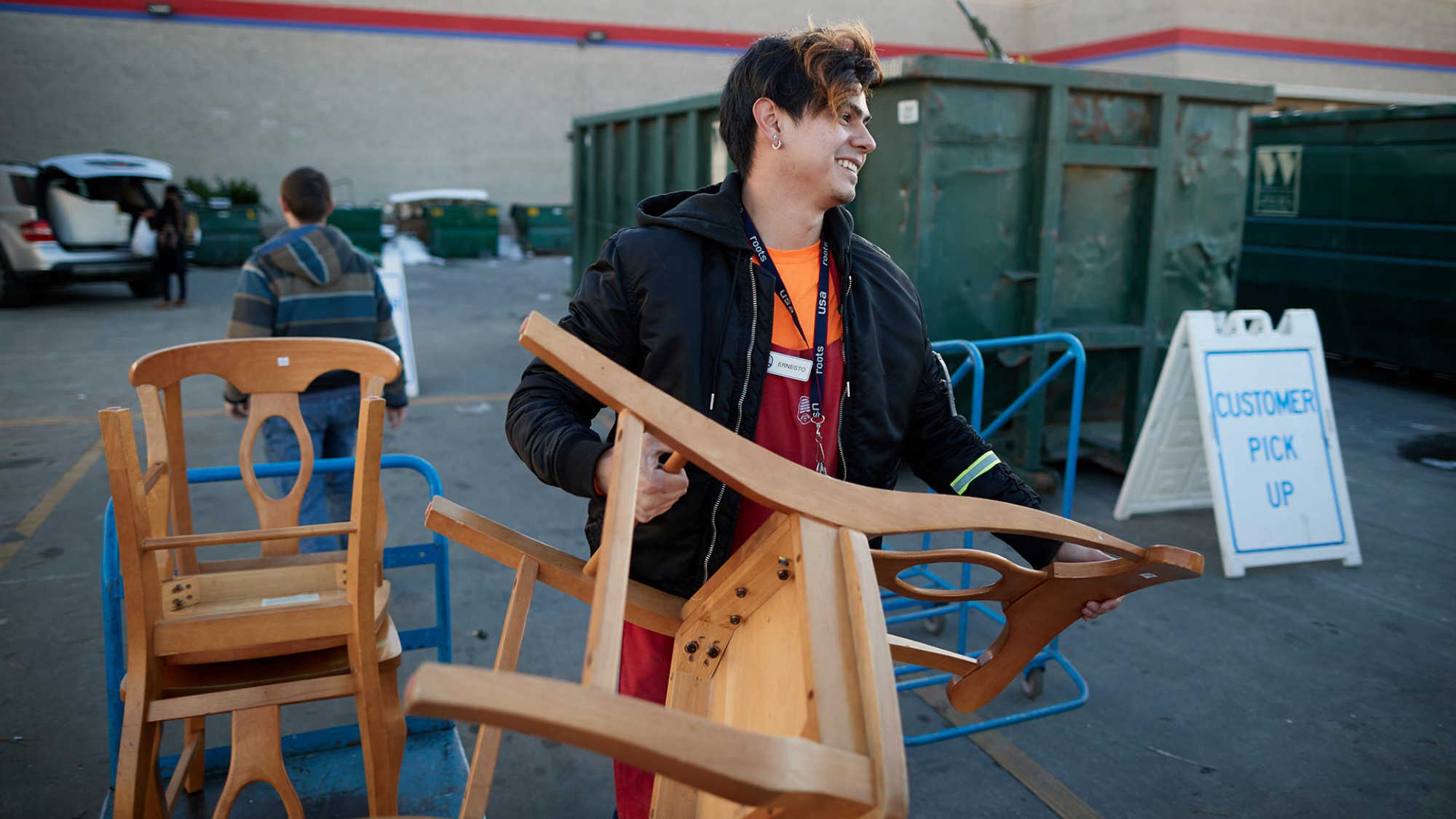 Associate Ernesto helps a customer pick up a donated chair