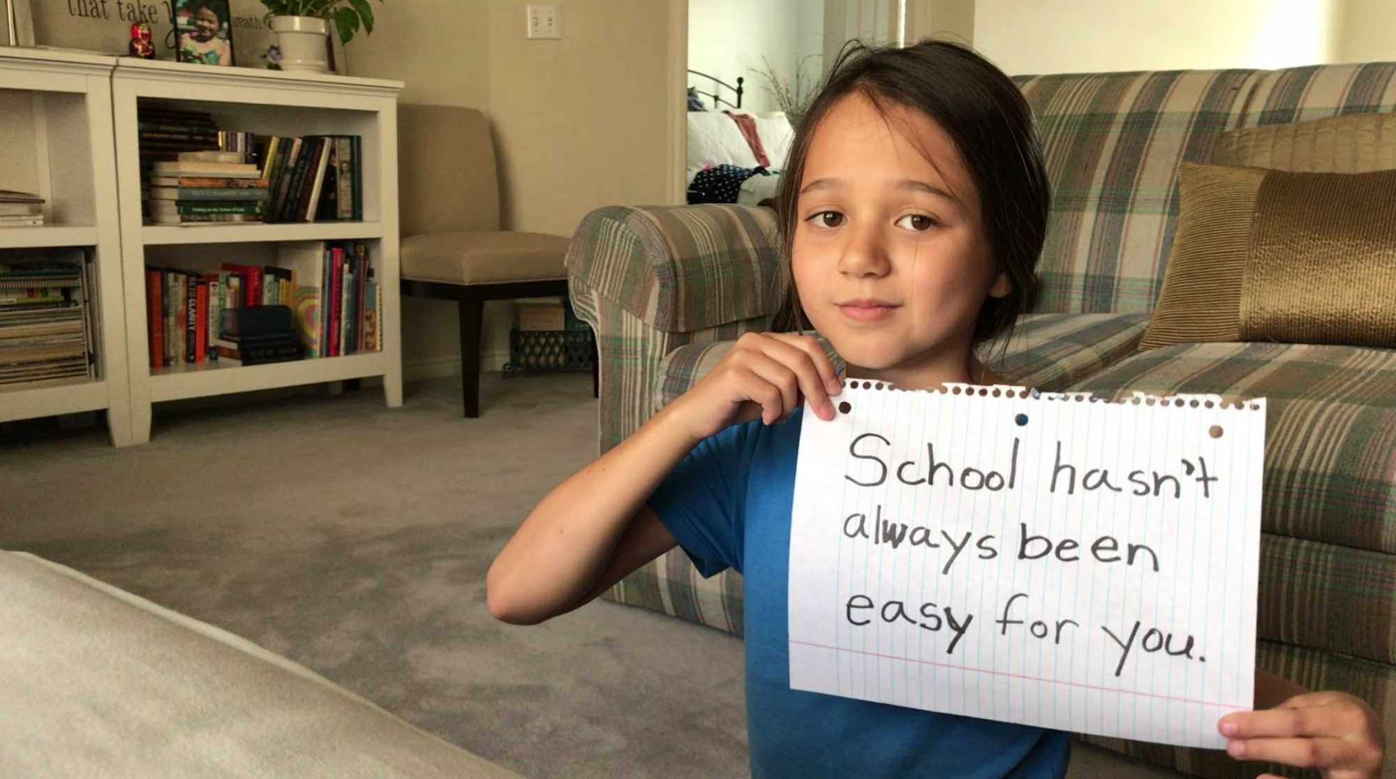 Little girl holds motivational poster