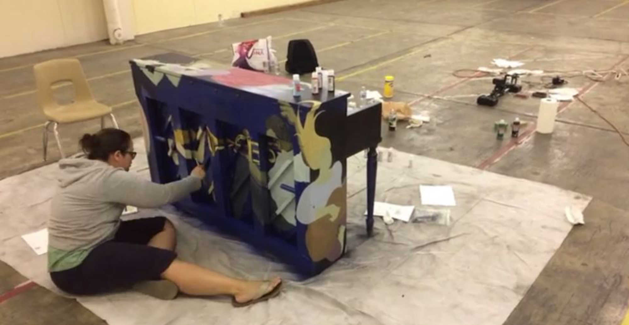 An artist paints a piano