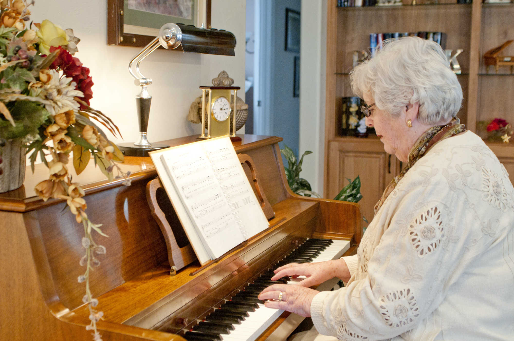 An older woman plays the piano