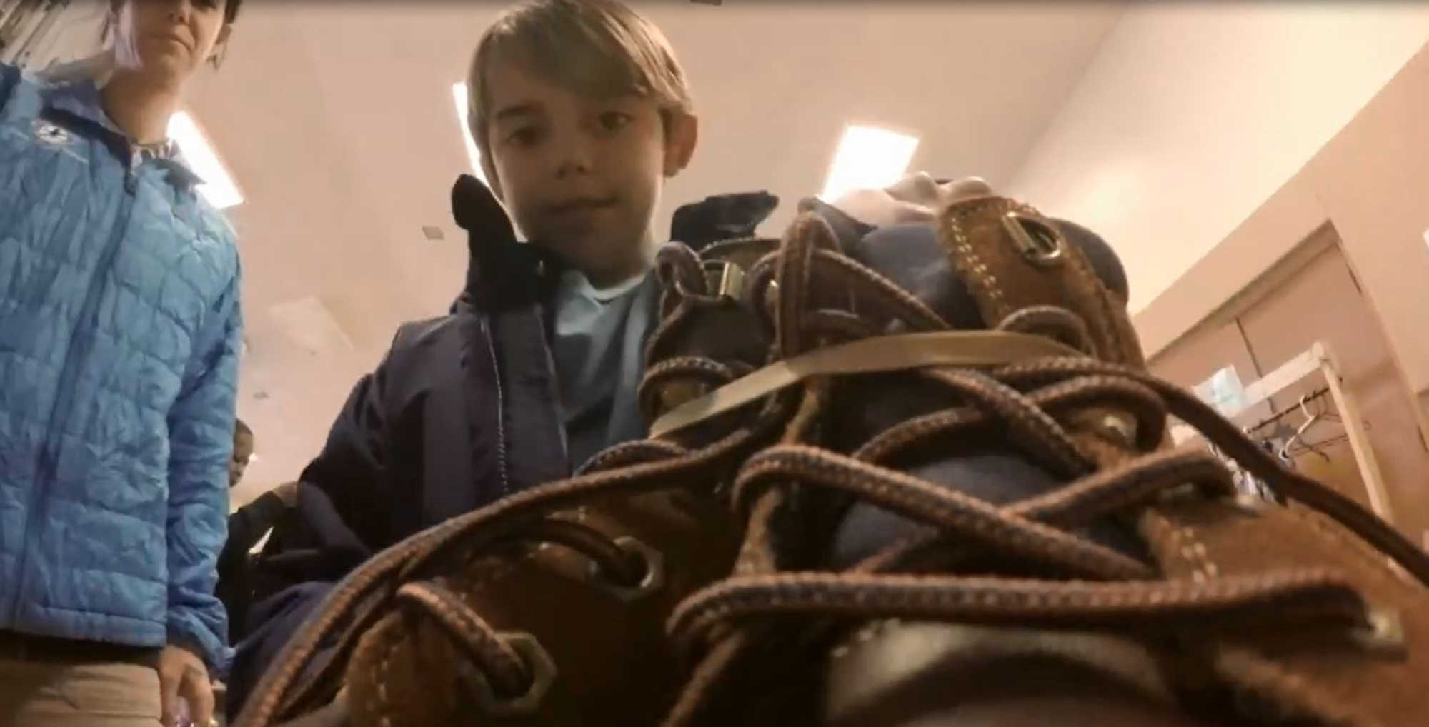 A little boy finds boots that were donated.