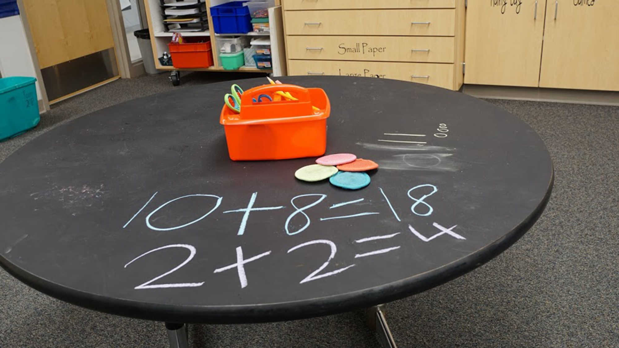 A chalkboard table with some repurposed erasers.